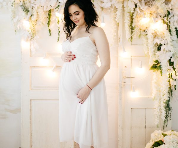 Couple of handsome husband and pretty pragnant woman posing at studio