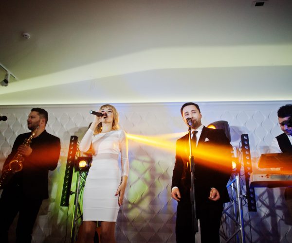 Musicial music live band performing on a stage with different lights.