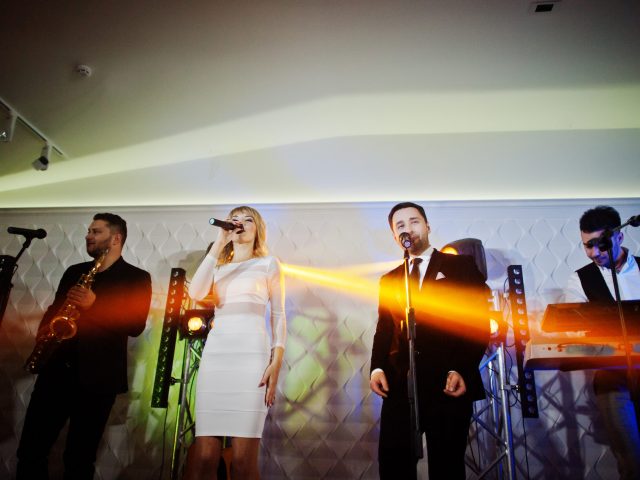 Musicial music live band performing on a stage with different lights.