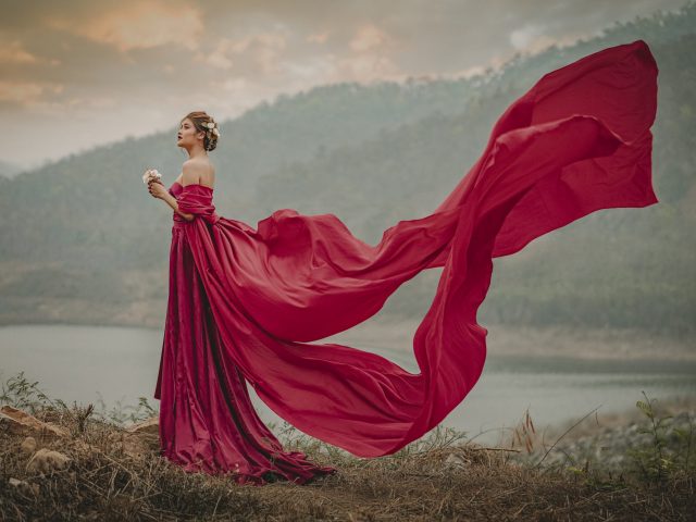 woman-red-dress-standing-lakeshore-sunset