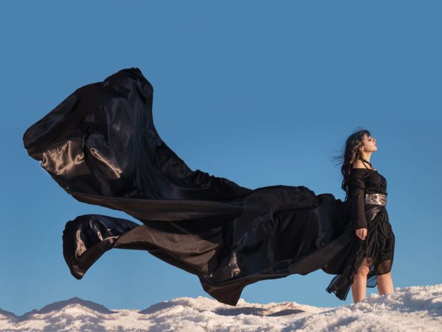 View of a beautiful young girl in gothic clothing on a salt hill.